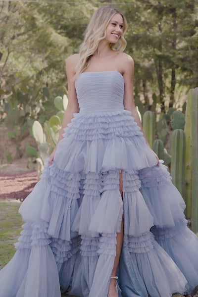 A stunning strapless tulle ball gown with a ruffle skirt and a stylish slit, perfect for prom and quinceañera celebrations. Available at Madeline's Boutique in Toronto and Boca Raton.  Video of Model wearing Sherri Hill 55677.