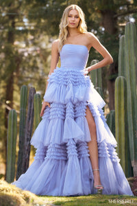 A stunning strapless tulle ball gown with a ruffle skirt and a stylish slit, perfect for prom and quinceañera celebrations. Available at Madeline's Boutique in Toronto and Boca Raton.
