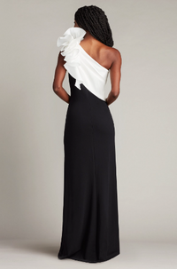 A woman wearing a one-shoulder evening dress with a sculptural flower detail, perfect for elegant evening occasions.