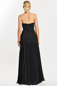 Model wearing Jovani 47000 strapless evening gown with floral waist detail and flowing pleated skirt.