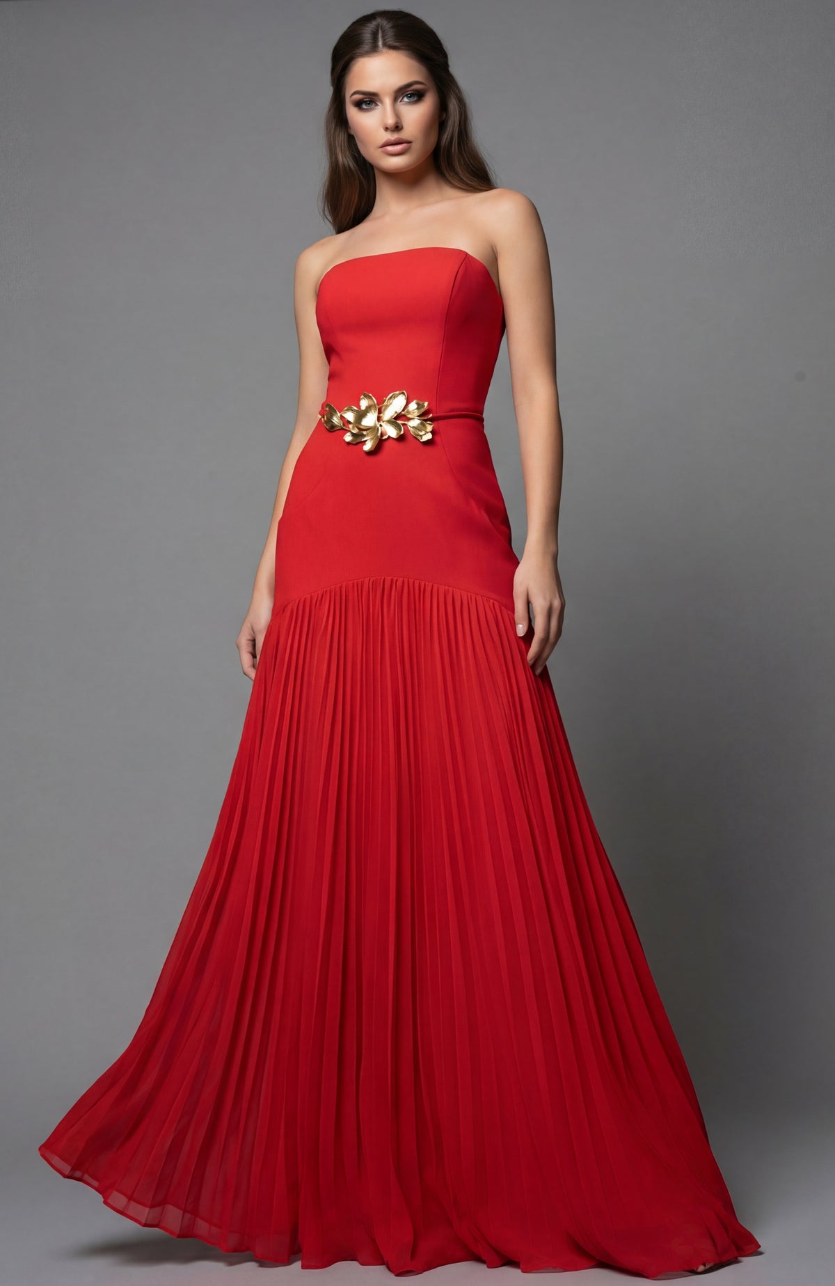 Model wearing Jovani 47000 strapless evening gown with floral waist detail and flowing pleated skirt.