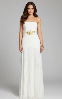 Model wearing Jovani 47000 strapless evening gown with floral waist detail and flowing pleated skirt.