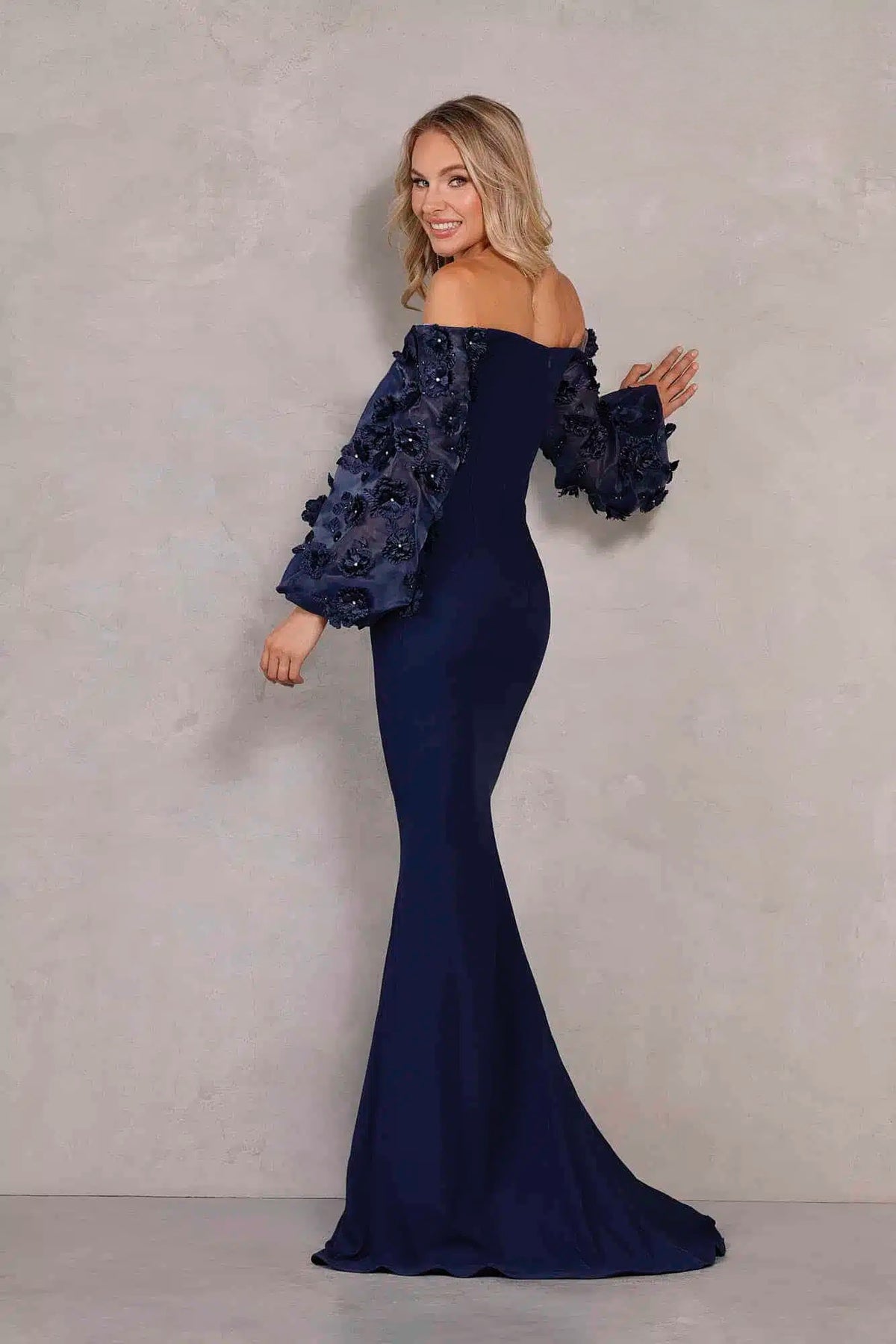 Terani Couture 1911E9128 Off Shoulder Floral Accent Puff Sleeves Gown in 2 Way Stretch Satin, perfect for mother of the bride or groom. Adorned with 3D flowers on organza sleeves. Dresses color is Navy.