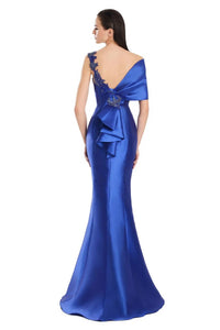 Model wearing Alexander by Daymor 3060S25 one-shoulder gown with draped back detail, fitted silhouette, and floor-length skirt.