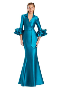 Model wearing Alexander by Daymor 3087S25 gown with mermaid skirt and high-neck jacket featuring dramatic ruffle sleeves and waist sash.