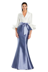 Model wearing Alexander by Daymor 3087S25 gown with mermaid skirt and high-neck jacket featuring dramatic ruffle sleeves and waist sash.