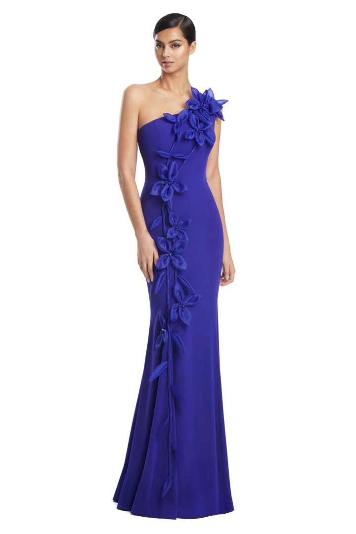 Model wearing Alexander by Daymor 3208S26 one-shoulder fitted gown with cascading floral appliqué detail.