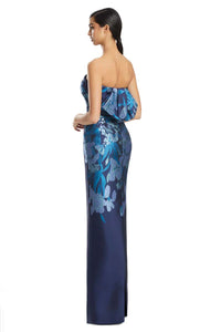 Woman wearing a blue floral strapless gown on a white background