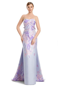 Woman wearing a strapless floral evening gown on a white background