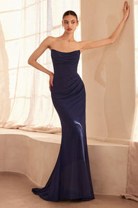 Woman wearing a navy blue strapless gown in a softly lit room.