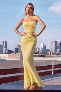 Woman in a yellow strapless gown on a rooftop with city skyline in the background