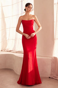 Woman wearing a strapless red evening gown in a softly lit room.