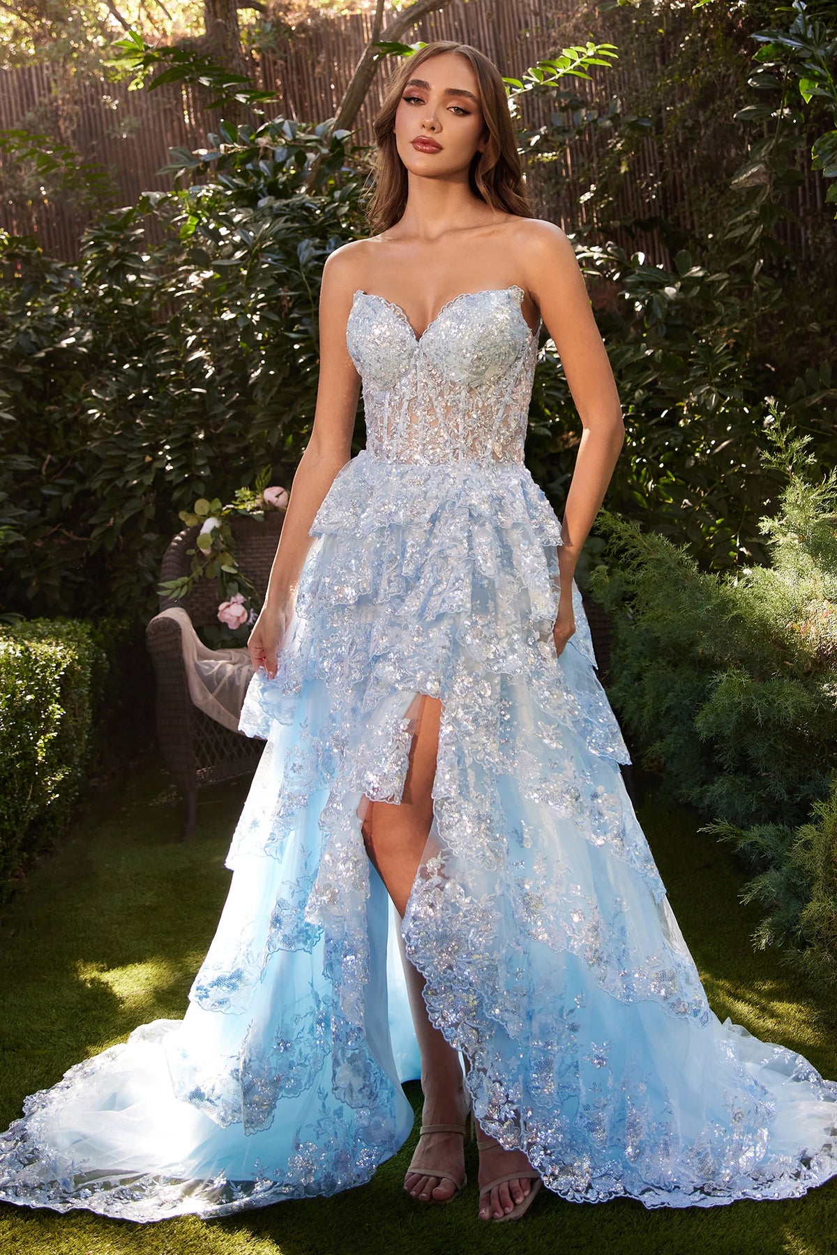 Andrea&Leo A1305 - A sparkling strapless A-line gown with tiered, layered skirt, sparkling scalloped lace hems, sheer boned bodice adorned with glistening sequins, and a lace-up corset back for a captivating look at prom.  The model is wearing the dress in light blue.