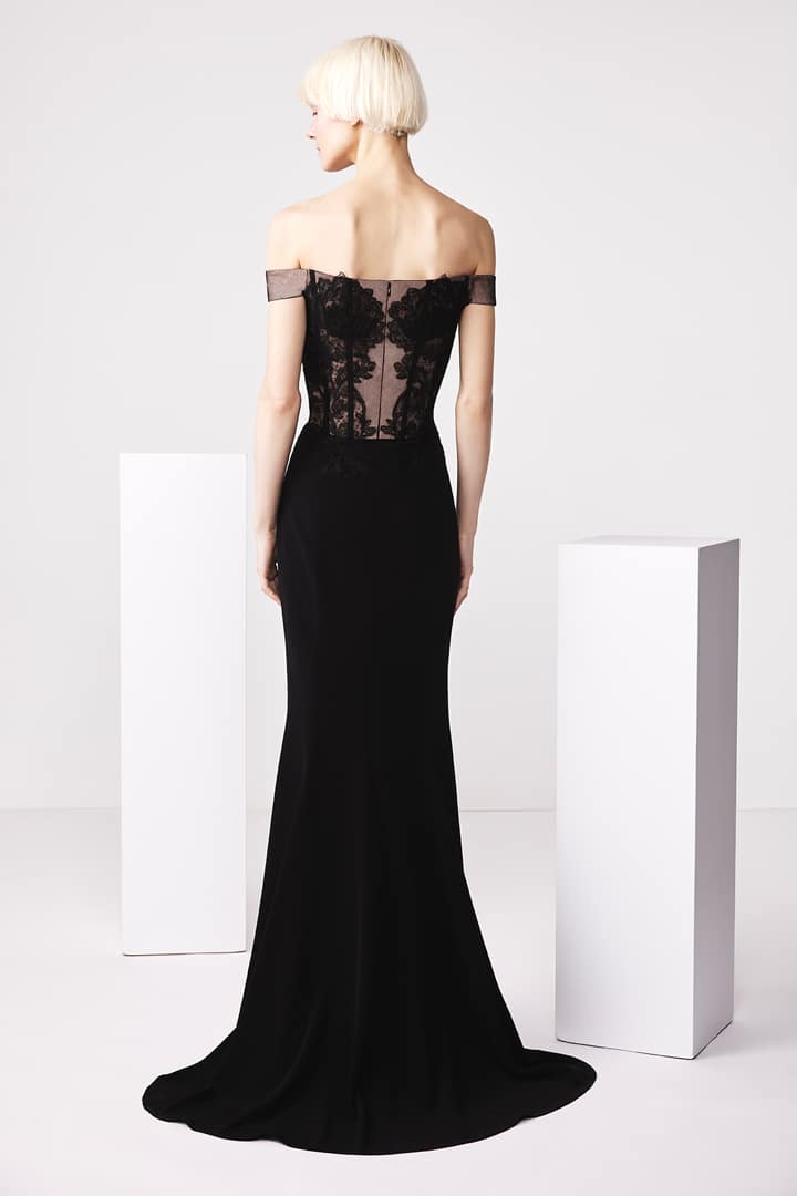 Model wearing Audrey+Brooks 6503 off-the-shoulder gown with sheer lace bodice and fit and flare silhouette.