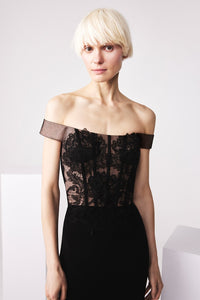 Model wearing Audrey+Brooks 6503 off-the-shoulder gown with sheer lace bodice and fit and flare silhouette.