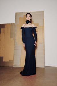 Model wearing Audrey+Brooks 6902 off-the-shoulder gown with detachable ruffled sleeves and fit-and-flare skirt.  Model is wearing the color Navy.  Front view.