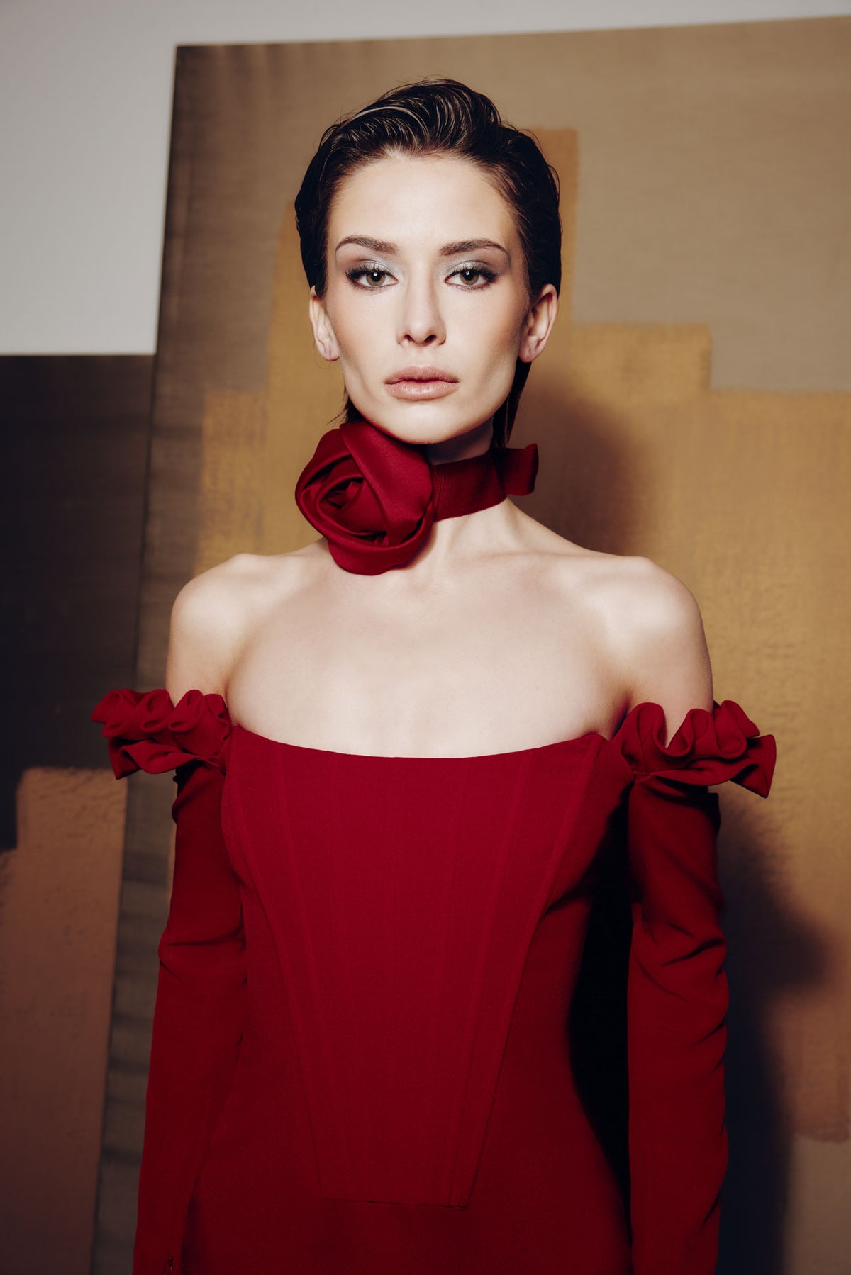 Model wearing Audrey+Brooks 6902 off-the-shoulder gown with detachable ruffled sleeves and fit-and-flare skirt.  Model is wearing the color red.  Close Up view.