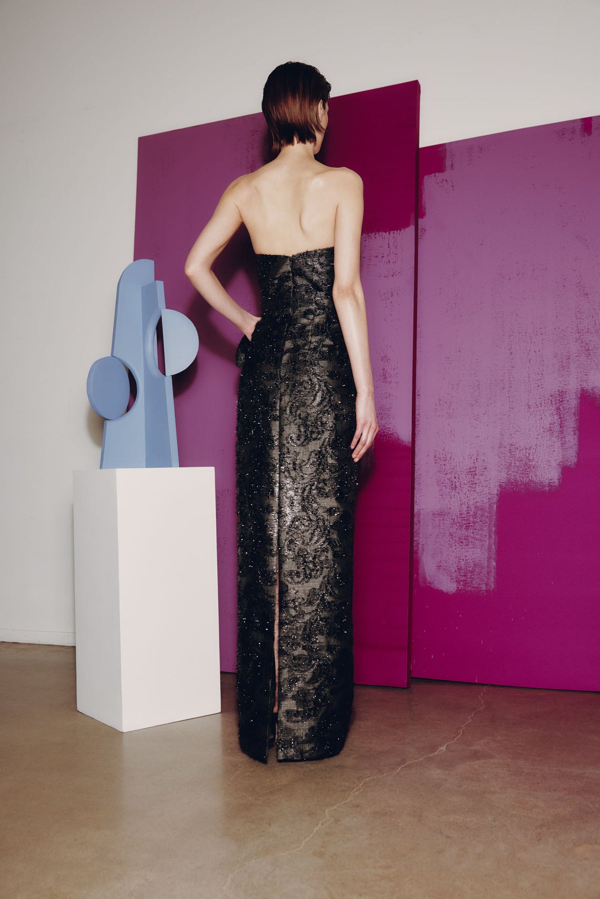 Model wearing Audrey+Brooks 6904 strapless evening gown with bow detail and column silhouette.