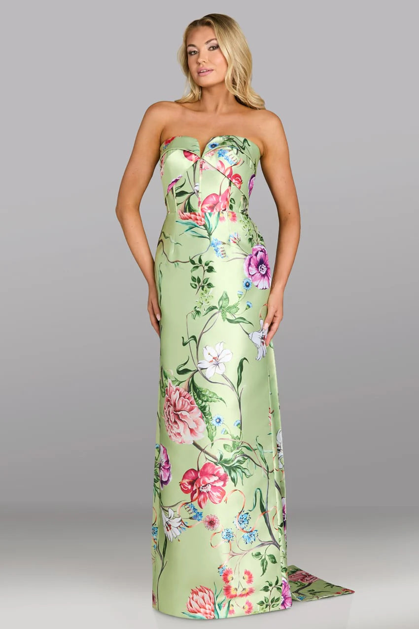Woman wearing a strapless floral gown against a gray background