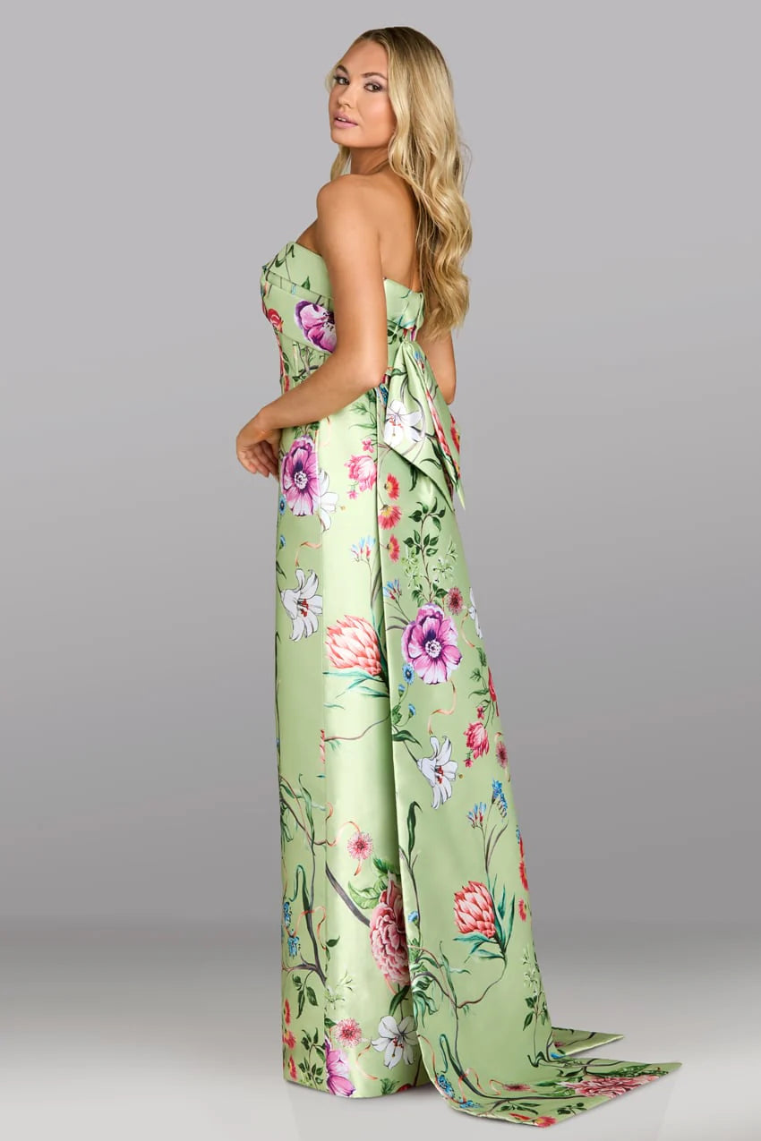 Woman wearing a green floral strapless jumpsuit on a gray background