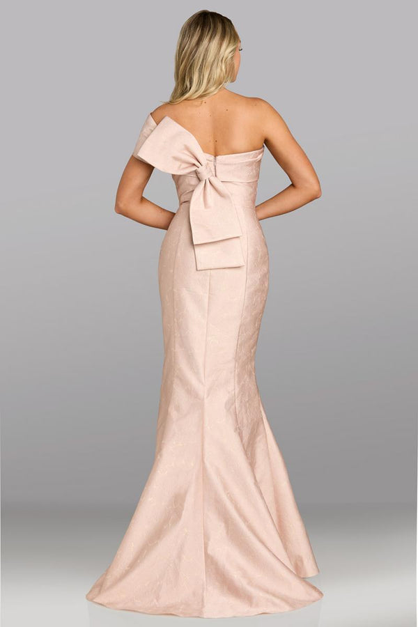 Model wearing Feriani Couture 18629 gown featuring a one-shoulder neckline, fitted silhouette, and elegant bow detail at the back.