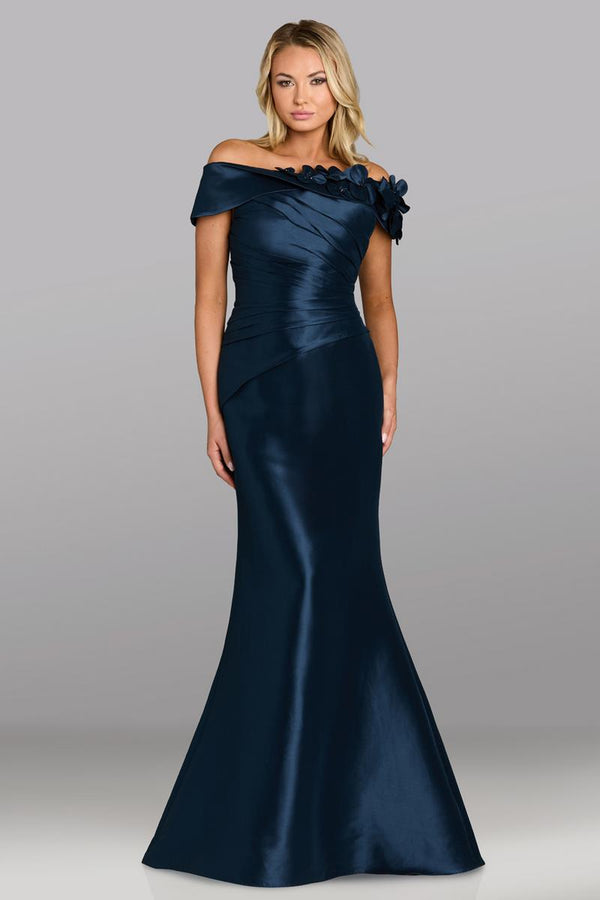Model wearing Feriani Couture 18639 off-the-shoulder gown with draped bodice, floral appliqué detailing, and a fitted silhouette.