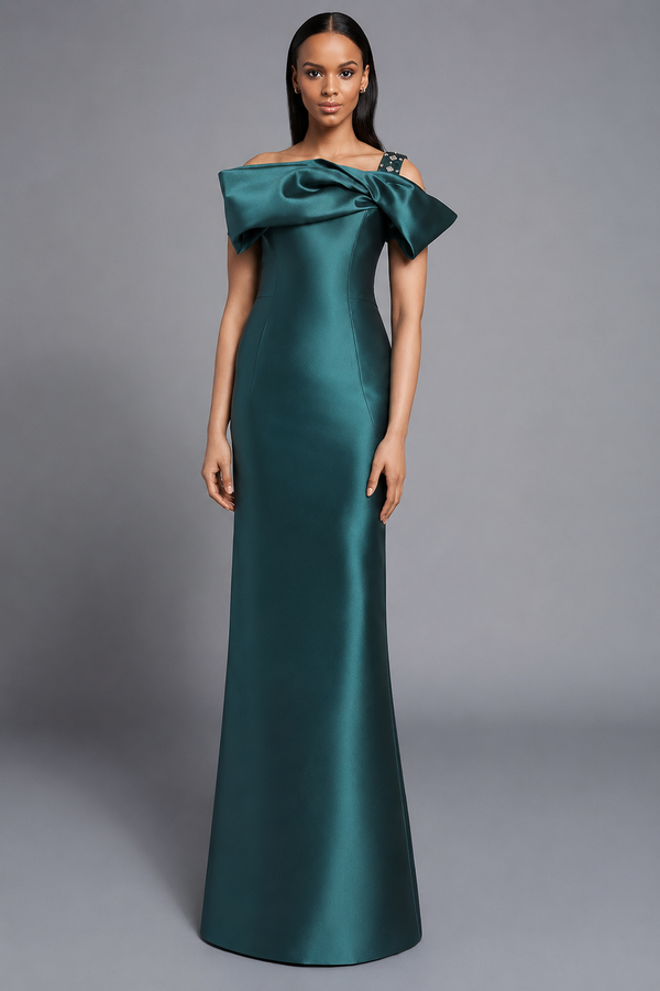 A woman modeling a floor-length off-the-shoulder gown in teal against a neutral gray studio background.