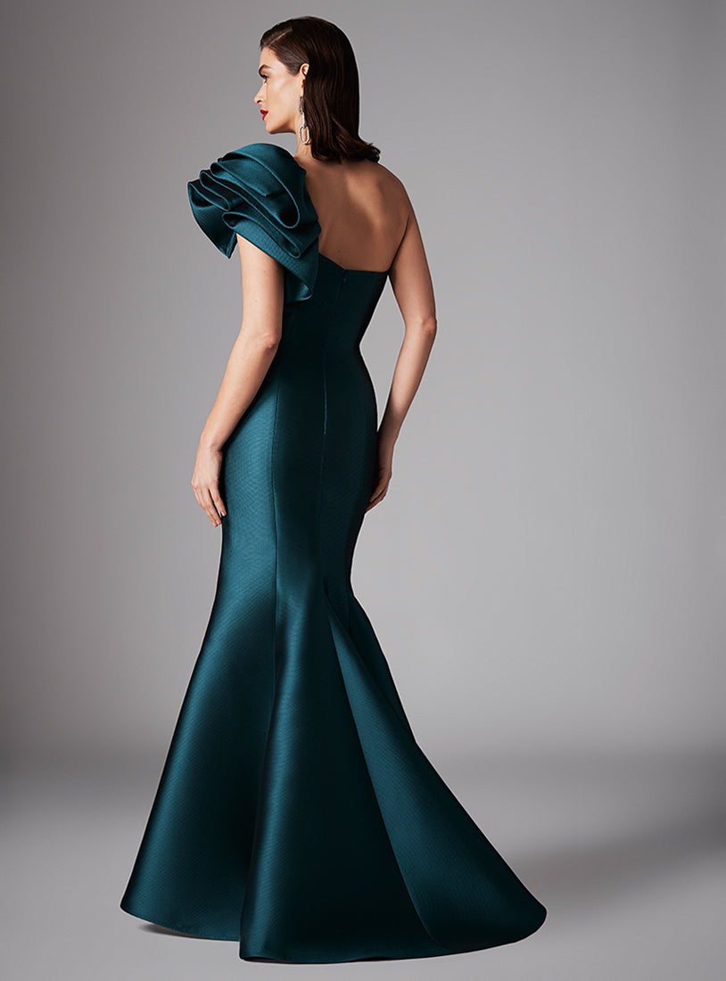 Step into sophistication with this Frascara mermaid dress. One-shoulder design with ruffles, structured bodice, and textured Ottoman material. Perfect for evening events and as Mother of the Bride or Groom. Available at Madeline's Boutique, Toronto & Boca Raton.