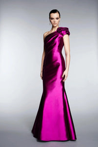 A model wearing an evening gown in purple color with a V-neckline and sleeveless design.