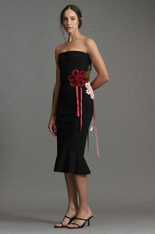 Model wearing Greta Constantine Gannatch strapless midi dress with flounce hem and statement bow detailing.