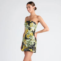 Woman wearing a strapless floral dress on a light gray background
