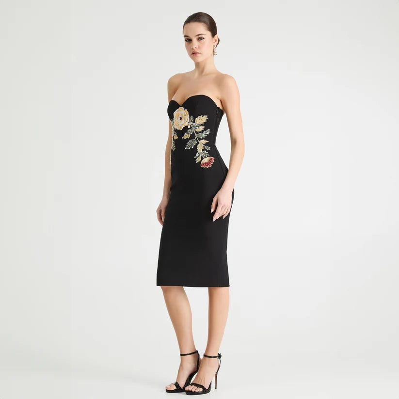 Black strapless dress with floral embroidery on a white background