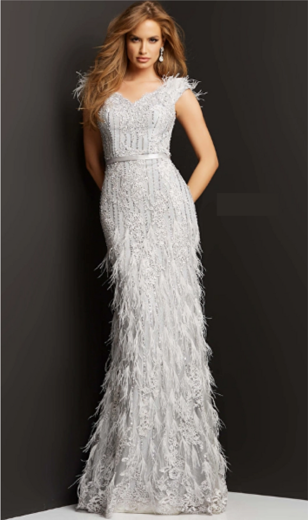 A woman wearing a stunning beaded and lace embroidered evening gown with feather embellished floor-length skirt, perfect for black tie events and red carpet occasions.