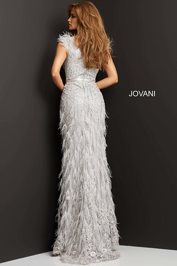 A woman wearing a stunning beaded and lace embroidered evening gown with feather embellished floor-length skirt, perfect for black tie events and red carpet occasions.