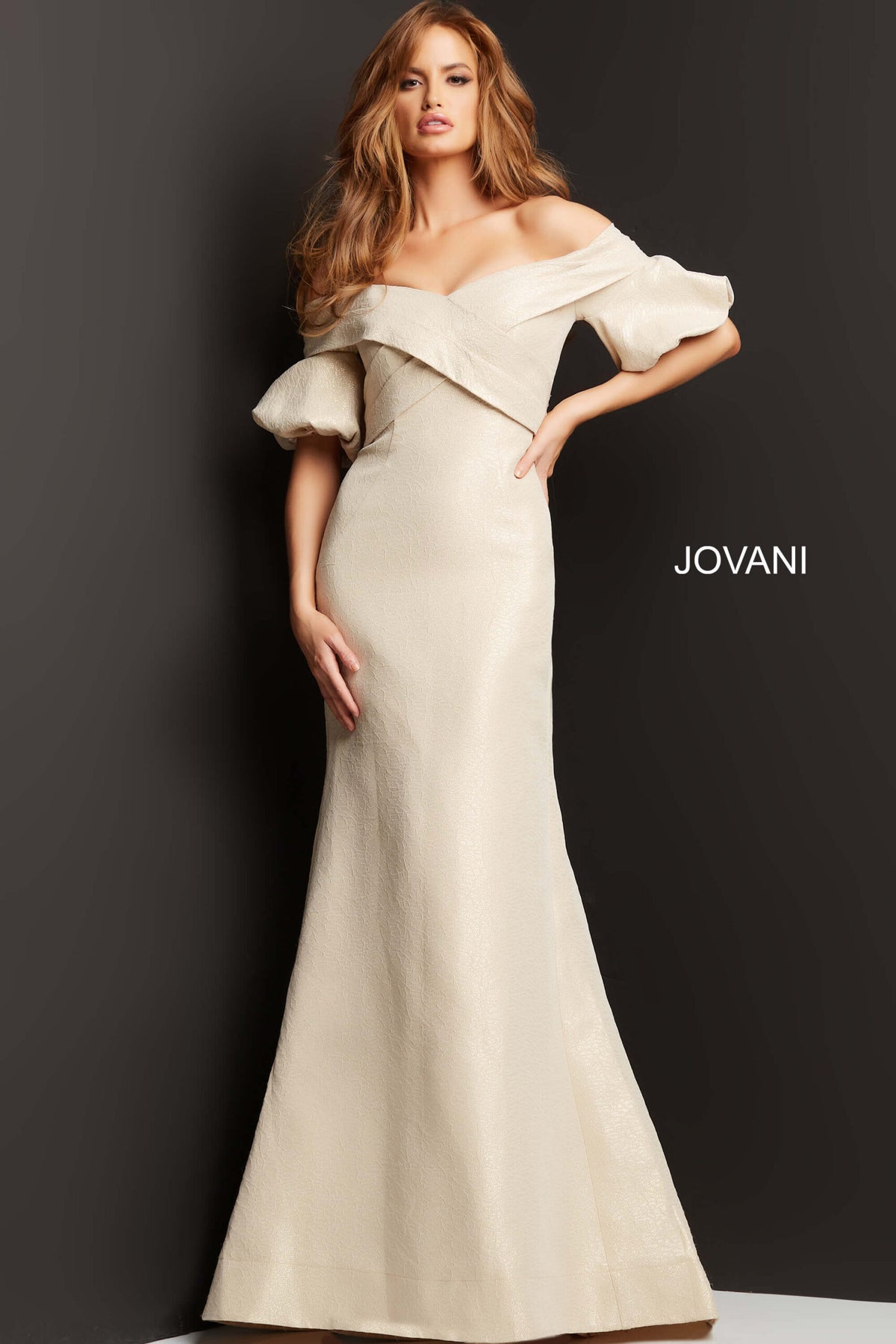 Model wearing Jovani 06831 off-the-shoulder puff sleeve mermaid gown with crossover bodice.