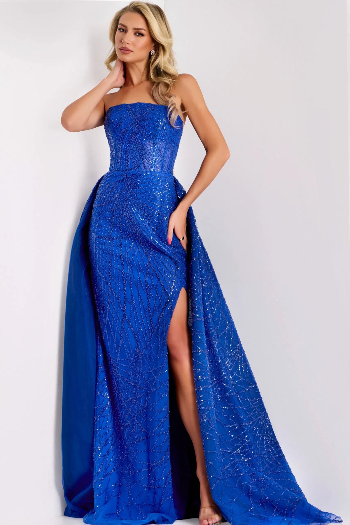 Model wearing Jovani 39029 strapless A-line gown with sequin embellishments and flowing overlay.