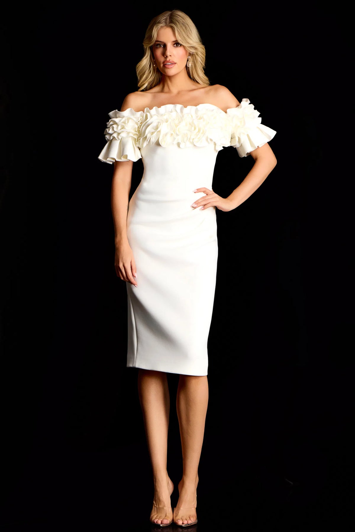 Woman wearing a white off-shoulder dress with ruffled details against a black background