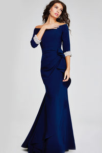 Model wearing Jovani 42409 off-the-shoulder gown with three-quarter sleeves, embellished cuffs, and draped side detail.