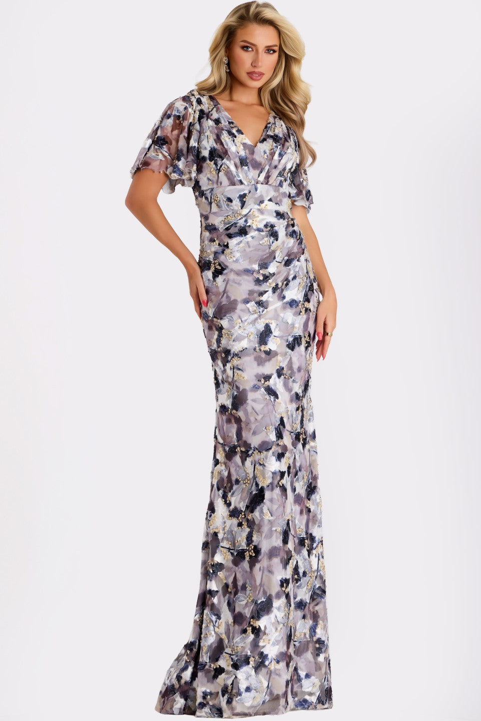 Model wearing Jovani 43046 sequin gown with flutter sleeves, V-neckline, and open back with tie detail.