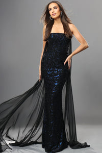 Woman wearing a black sequin gown with sheer overlay on a gray background