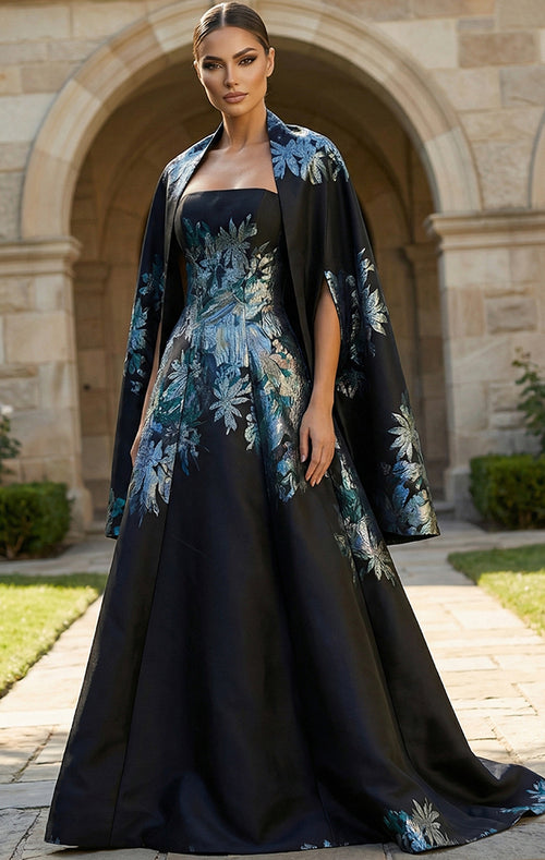 Model wearing Jovani 45578 strapless A-line gown with floral detailing and matching cape.