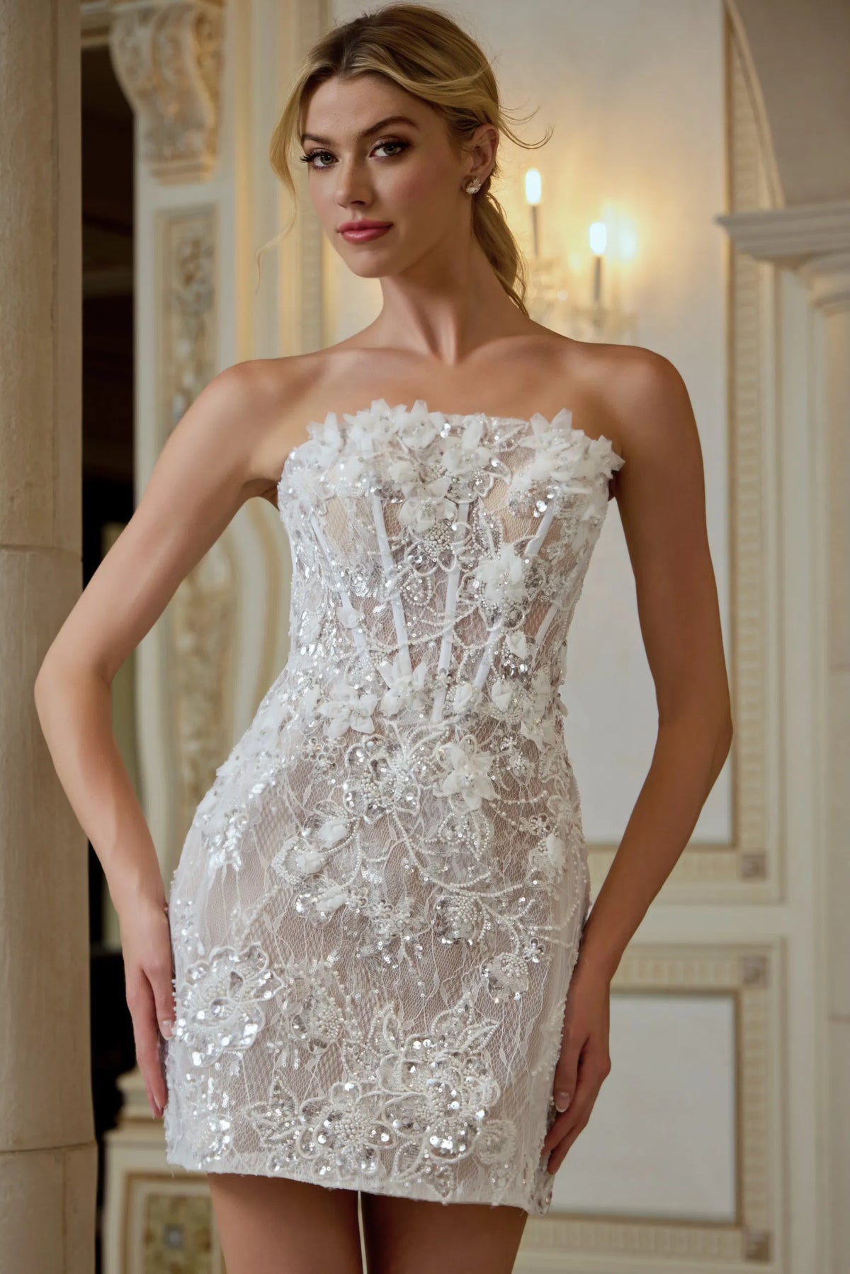 Woman wearing a strapless, intricately designed white dress in an elegant indoor setting.