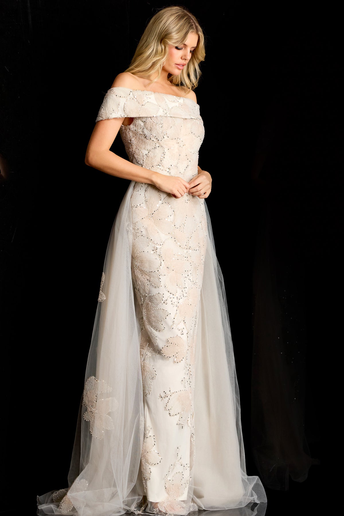 Model wearing Jovani 46034 off-shoulder embellished column gown with removable overskirt and fitted silhouette.