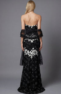 Black strapless evening gown with white floral pattern on a gray background