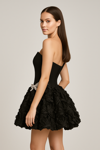 Model wearing Jovani 46486 strapless cocktail dress with corset bodice, rosette skirt, and embellished bow detail at the waist.