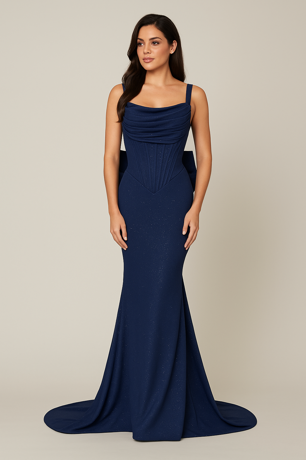 Model wearing Jovani 47669 sleeveless fitted gown with draped bodice, bow back detail, and sweep train.