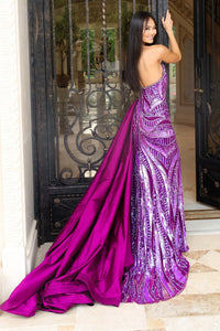 Woman in a purple evening gown standing in front of a decorative door.