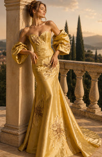 Model wearing Jovani 49625 strapless mermaid gown with oversized floral appliqué details, dramatic puff sleeves, and a fitted floor-length silhouette.