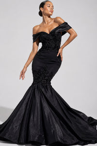 A woman modeling a black off-the-shoulder mermaid gown with a heavily embellished beaded bodice and a full satin skirt, photographed against a light gray studio background.