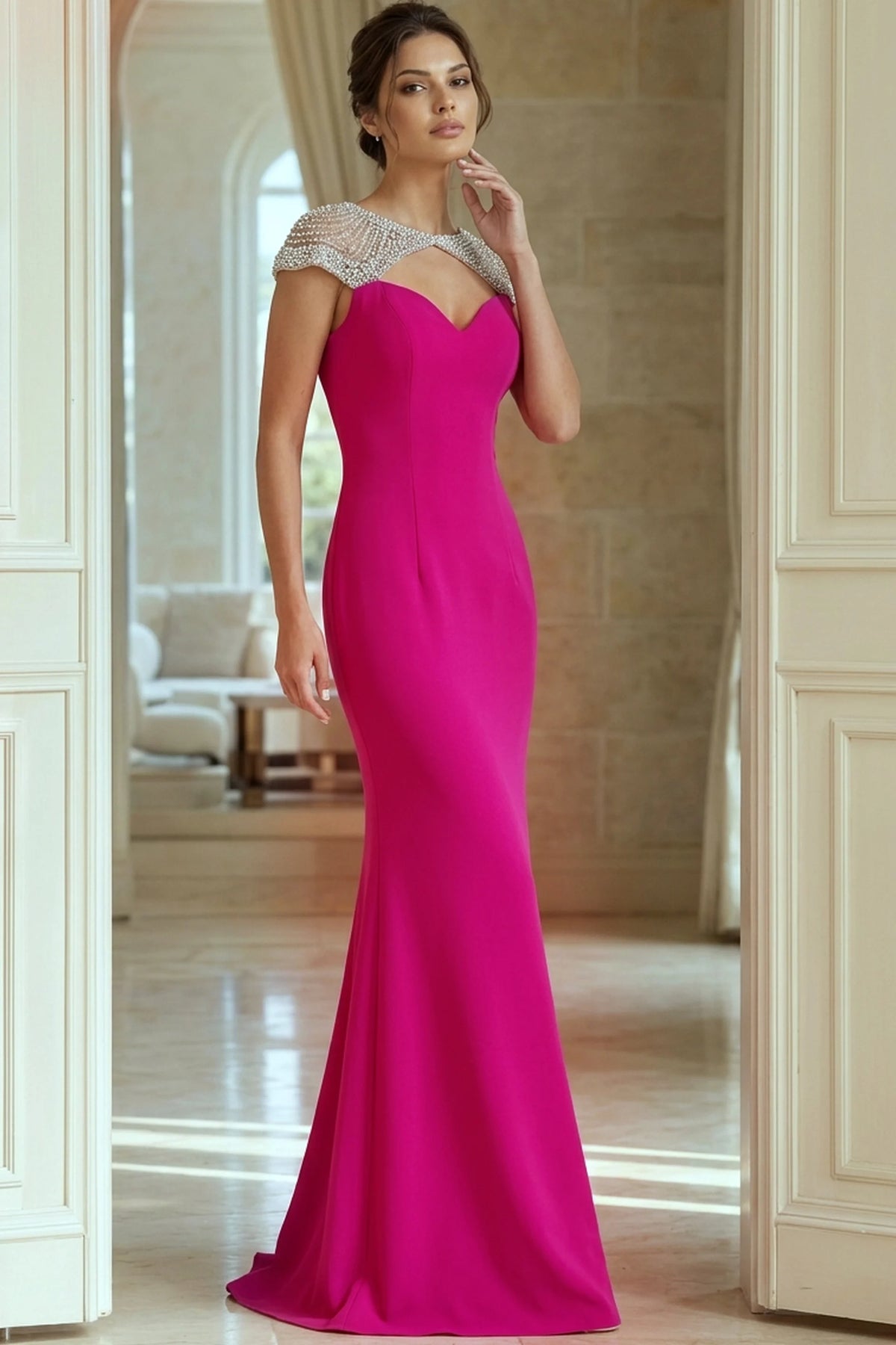Woman wearing a fuchsia evening gown with a beaded neckline in an elegant interior setting.